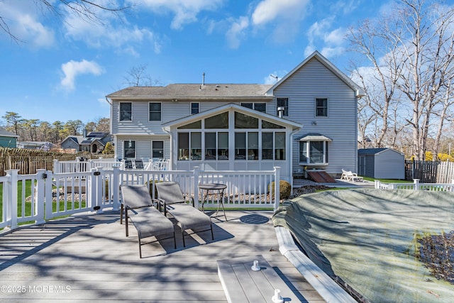 back of property featuring a sunroom, fence, and a deck