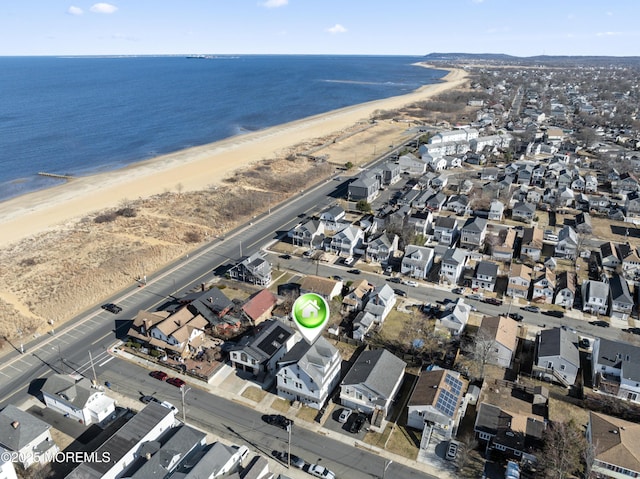 birds eye view of property featuring a water view, a residential view, and a beach view