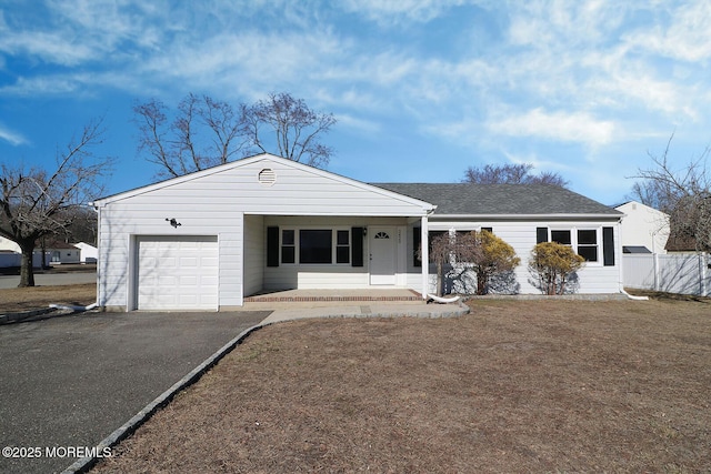 ranch-style house with a garage, driveway, fence, and roof with shingles