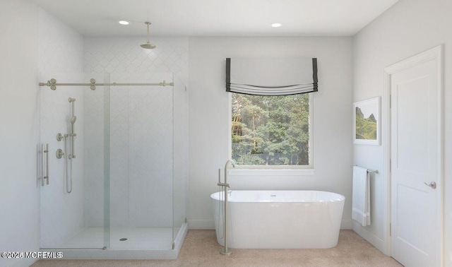 bathroom with a soaking tub, a shower stall, and recessed lighting