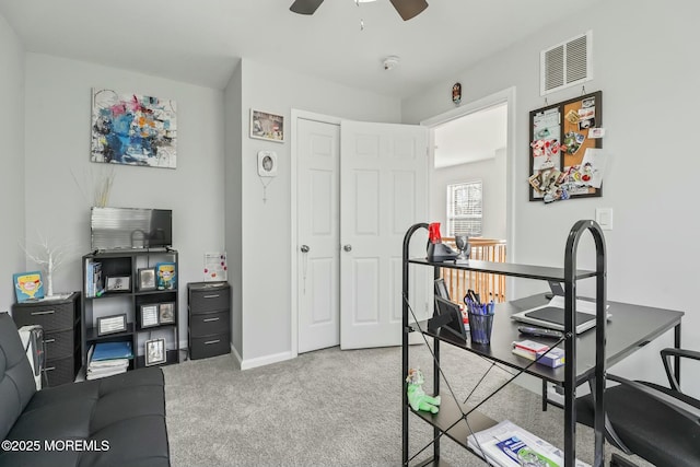 carpeted home office with a ceiling fan, visible vents, and baseboards