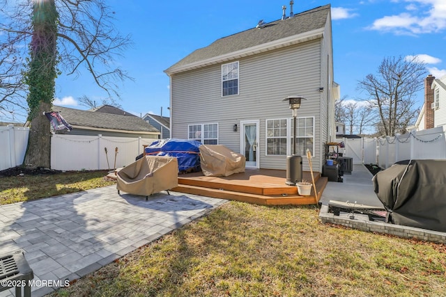 rear view of property featuring a yard, a fenced backyard, a deck, and a patio