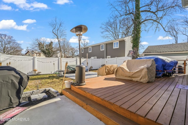 deck with a patio area, a fenced backyard, and a grill