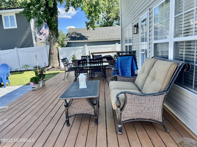 deck featuring outdoor dining area and a fenced backyard