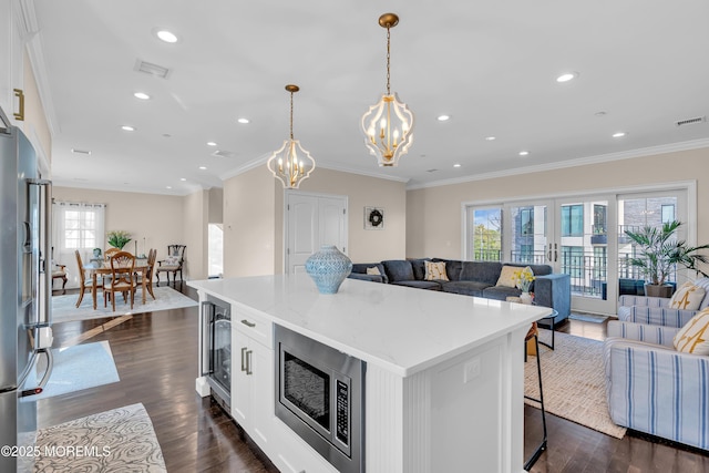 kitchen featuring visible vents, dark wood-type flooring, appliances with stainless steel finishes, open floor plan, and a center island