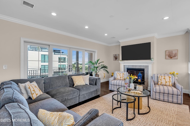 living room featuring wood finished floors, baseboards, visible vents, recessed lighting, and ornamental molding