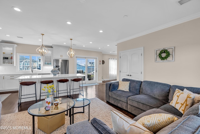 living room featuring dark wood finished floors, plenty of natural light, and crown molding