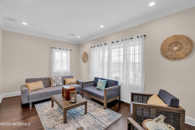 living room with crown molding, baseboards, and wood finished floors