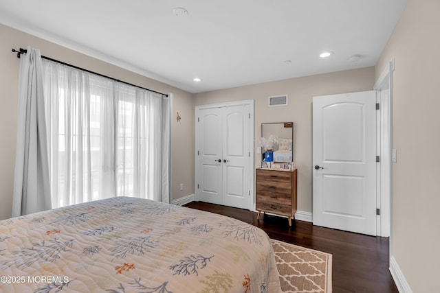 bedroom featuring dark wood-type flooring, recessed lighting, baseboards, and a closet