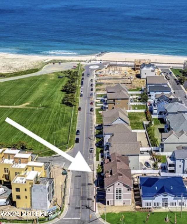 birds eye view of property featuring a view of the beach, a water view, and a residential view