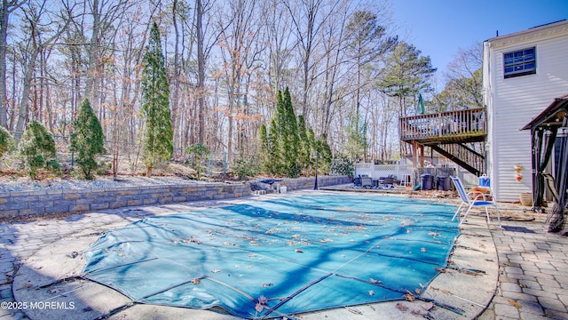 view of pool with a fenced in pool, stairway, a patio area, fence, and a wooden deck