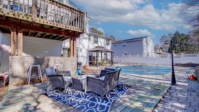 view of patio / terrace with fence, a fenced in pool, and a gazebo