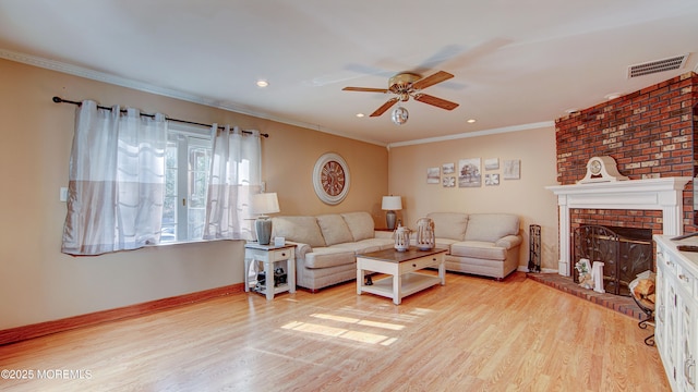 living area with baseboards, visible vents, crown molding, light wood-type flooring, and a fireplace