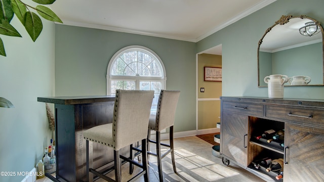 dining room featuring baseboards, light tile patterned floors, and crown molding