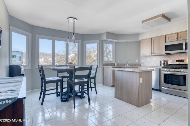 kitchen with baseboards, light brown cabinetry, stainless steel appliances, tasteful backsplash, and a center island