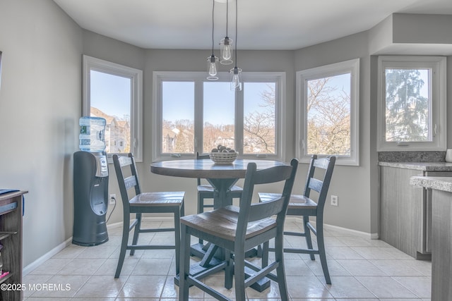 dining space with baseboards, a healthy amount of sunlight, and light tile patterned flooring