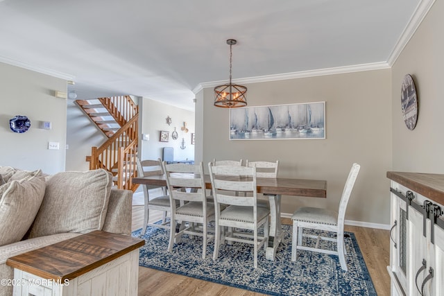 dining area with stairs, light wood-style flooring, a chandelier, and ornamental molding