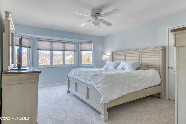 bedroom with light carpet, baseboards, and a ceiling fan