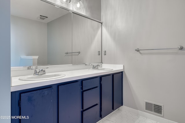 full bath with a sink, visible vents, and double vanity