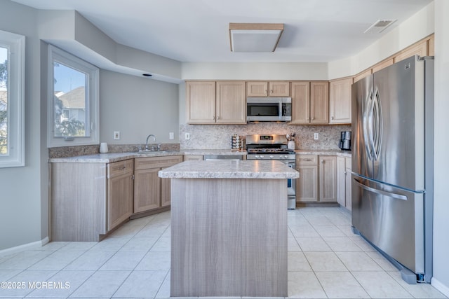 kitchen with light tile patterned floors, visible vents, a kitchen island, a sink, and appliances with stainless steel finishes