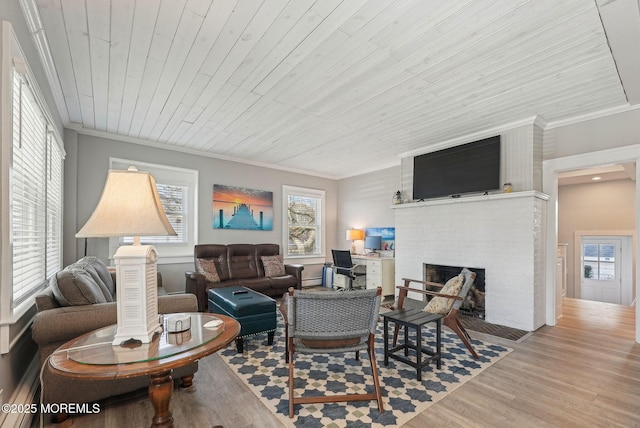 living room featuring ornamental molding, wooden ceiling, wood finished floors, and a brick fireplace