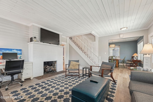 living room with wooden ceiling, stairway, wood finished floors, crown molding, and a fireplace