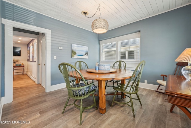 dining space with a baseboard radiator, wood ceiling, baseboards, and wood finished floors