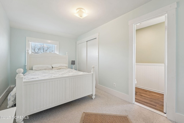 bedroom featuring a closet, wainscoting, and carpet flooring