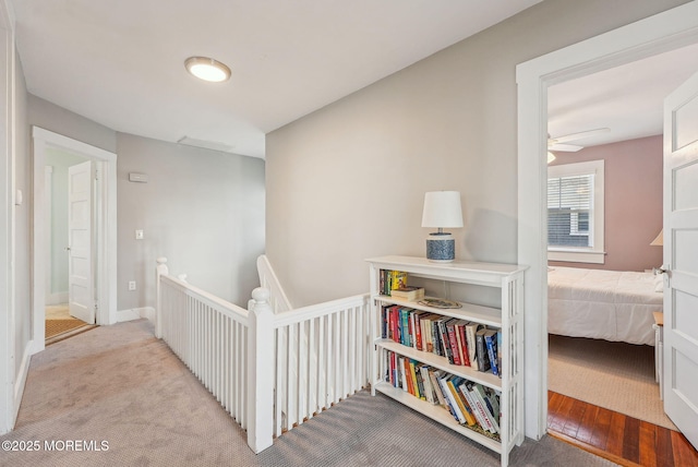 corridor with carpet floors and an upstairs landing