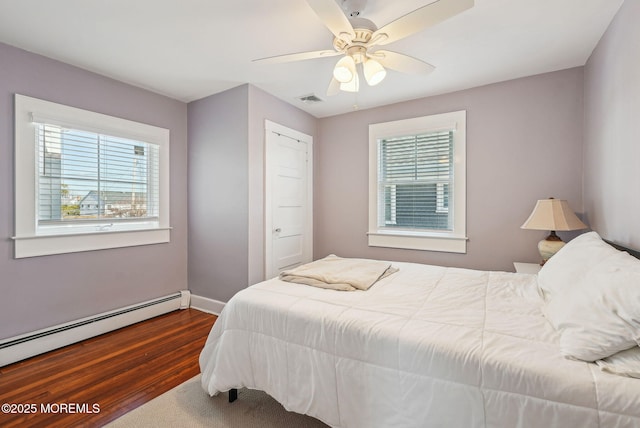 bedroom with visible vents, baseboards, a ceiling fan, a baseboard radiator, and wood finished floors