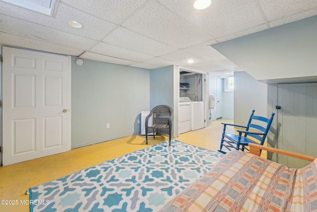 sitting room with washer and clothes dryer, a drop ceiling, and baseboards