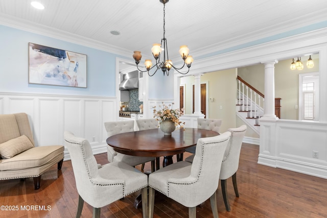 18 Riverdale Ave, Monmouth Beach, NJ 07750 - dining space featuring ornate columns, a chandelier, dark wood-style floors, a decorative wall, and crown molding