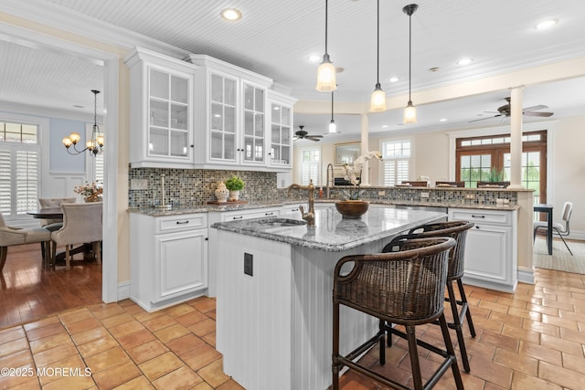 18 Riverdale Ave, Monmouth Beach, NJ 07750 - kitchen with a ceiling fan, ornamental molding, tasteful backsplash, a breakfast bar area, and a peninsula
