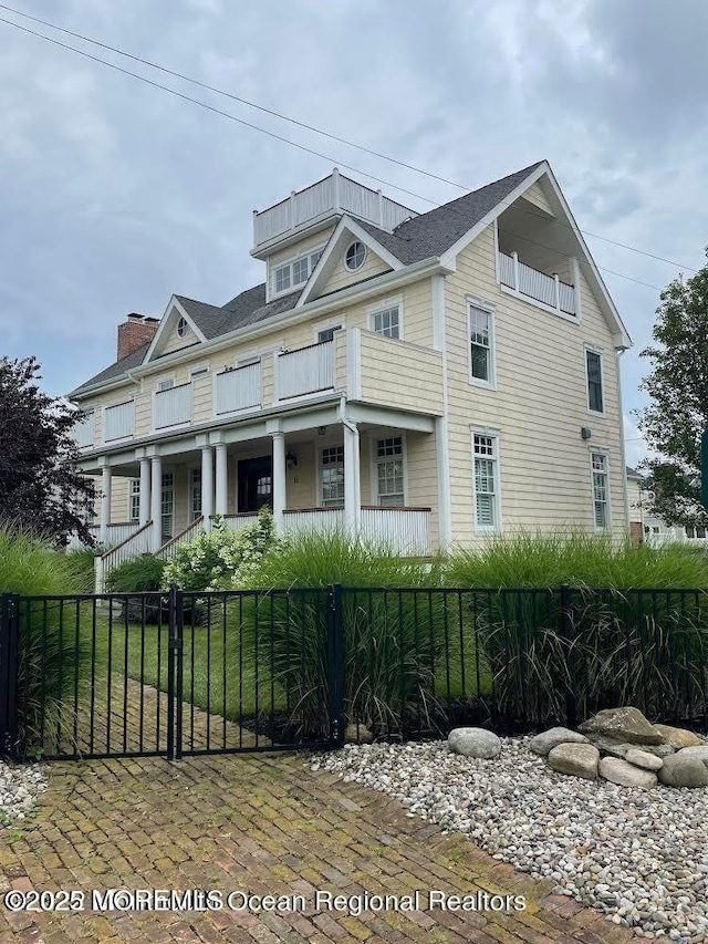 18 Riverdale Ave, Monmouth Beach, NJ 07750 - view of front of house with a fenced front yard, a balcony, and covered porch