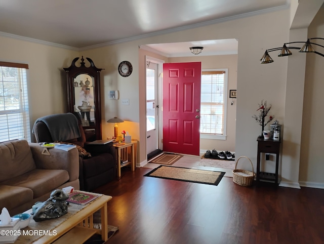 foyer featuring baseboards, wood finished floors, and crown molding