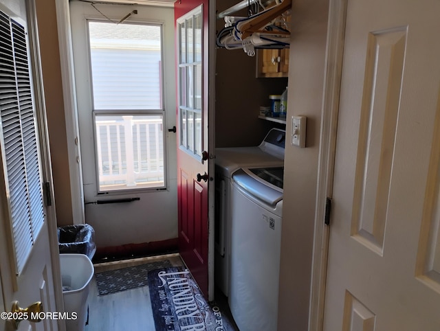 clothes washing area with cabinet space, a heating unit, washer and dryer, and wood finished floors