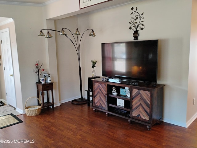 living room featuring baseboards, crown molding, and wood finished floors