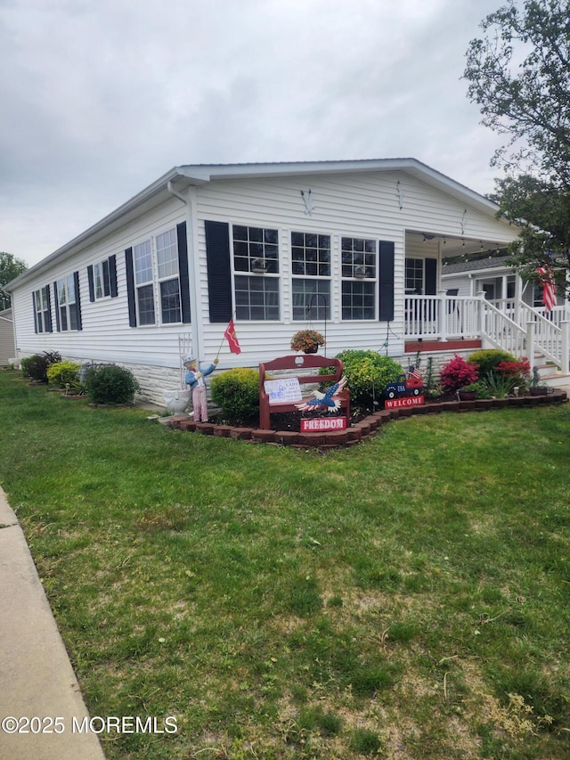 back of property featuring covered porch and a lawn