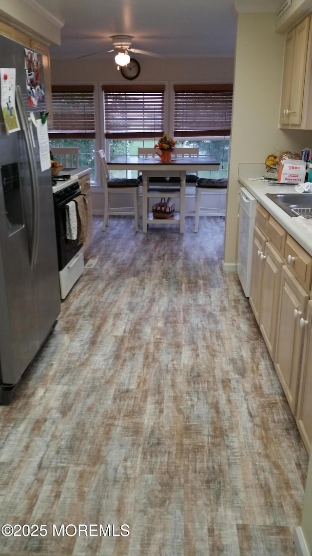 kitchen featuring range with gas stovetop, stainless steel refrigerator with ice dispenser, light wood finished floors, light countertops, and dishwasher