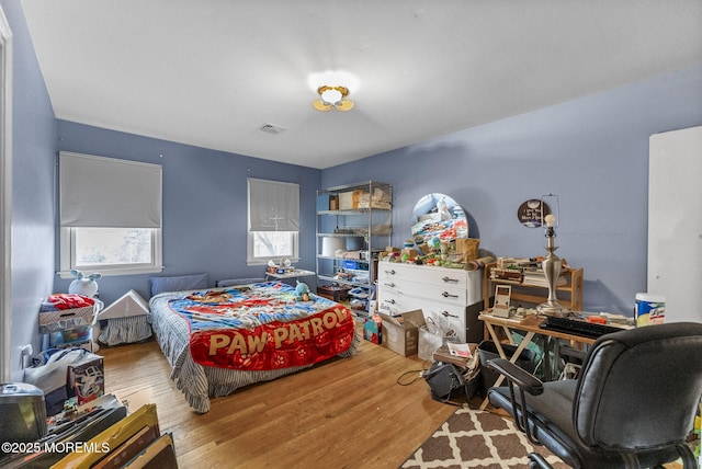 bedroom featuring visible vents and wood finished floors