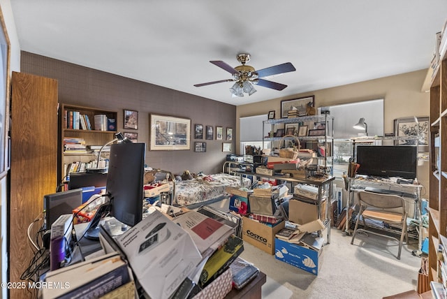 carpeted office with a ceiling fan