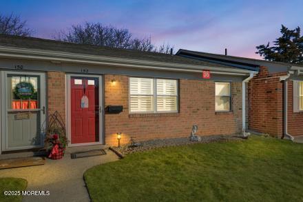 exterior space with brick siding and a yard