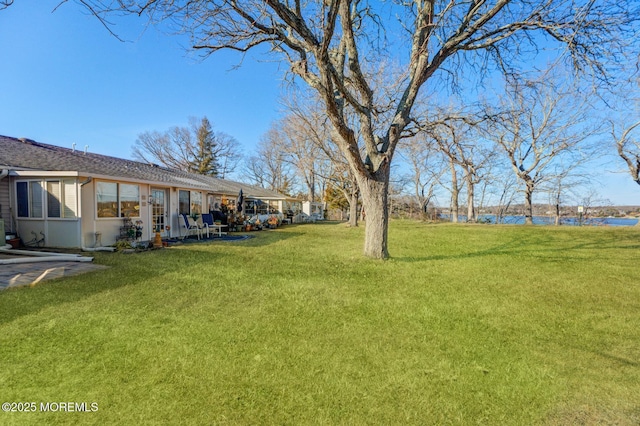 view of yard with a water view and a patio