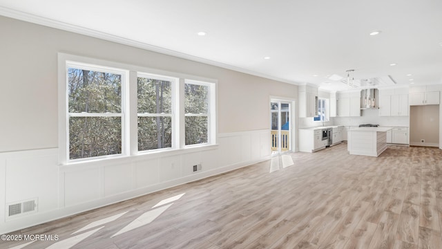 unfurnished living room with crown molding, light wood-type flooring, visible vents, and recessed lighting