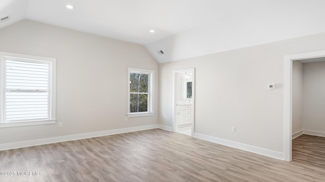 empty room with light wood-type flooring, vaulted ceiling, baseboards, and recessed lighting