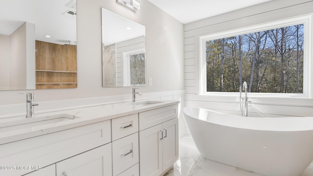 bathroom featuring marble finish floor, a sink, and a healthy amount of sunlight