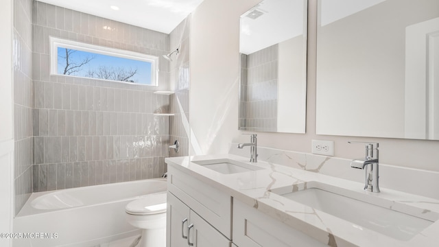 bathroom featuring double vanity, tub / shower combination, a sink, and toilet