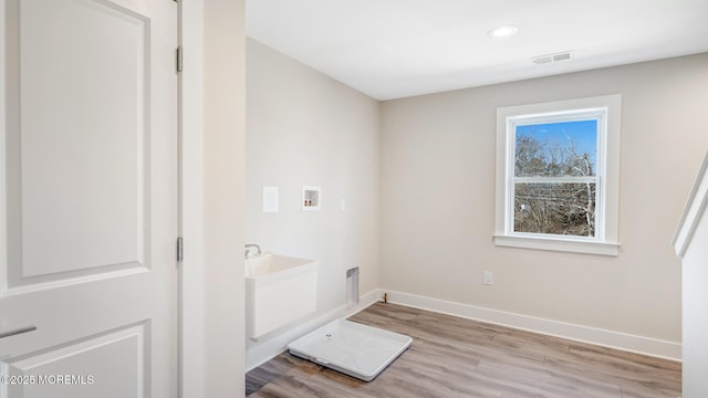 laundry area featuring laundry area, baseboards, visible vents, hookup for a washing machine, and light wood-type flooring