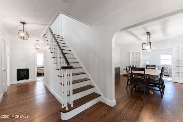 staircase with baseboards, arched walkways, wood finished floors, and crown molding