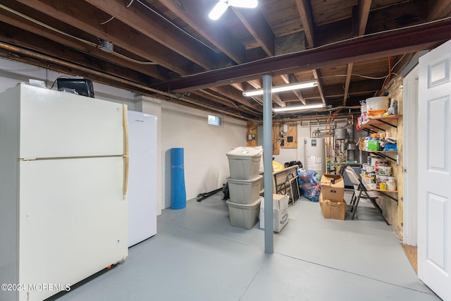 unfinished basement featuring gas water heater and freestanding refrigerator